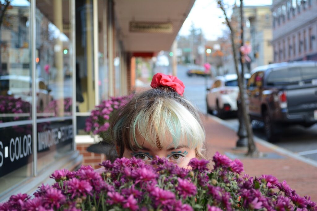 Woman peeping up over some flowers