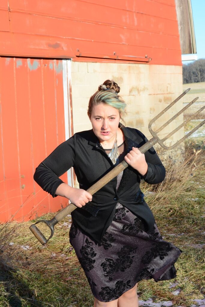 Farmer woman dressed up in a fancy dress showing the despair of dreams unrealized.